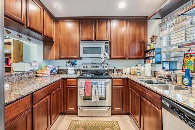 kitchen with light stone counters, sink, light tile patterned floors, and appliances with stainless steel finishes