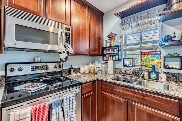 kitchen with light stone counters, sink, and stainless steel appliances