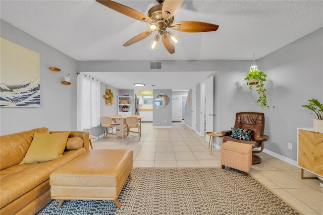 tiled living room featuring a textured ceiling and ceiling fan