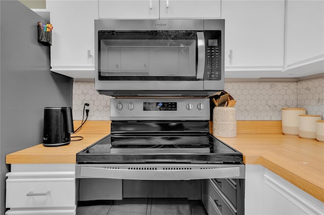 kitchen with backsplash, white cabinets, and stainless steel appliances