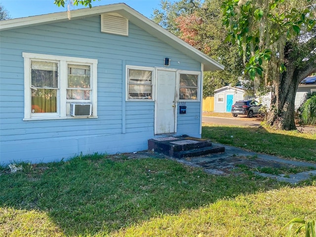 rear view of house featuring a yard and cooling unit