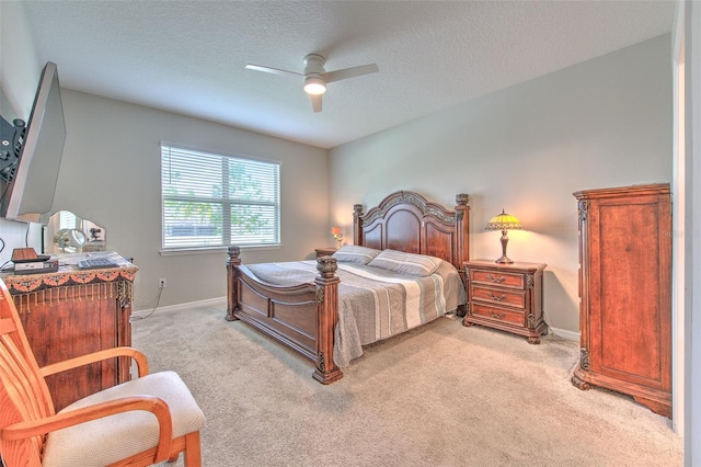 carpeted bedroom featuring ceiling fan and a textured ceiling