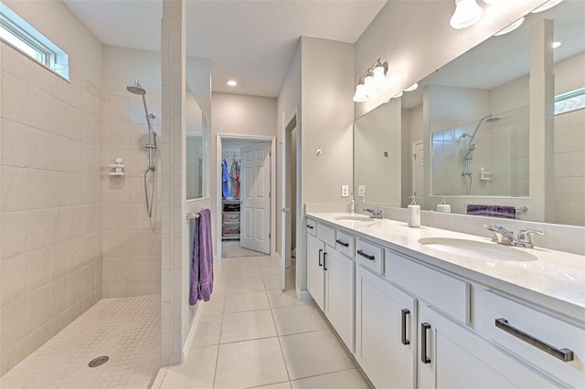 bathroom featuring tile patterned floors, a wealth of natural light, vanity, and tiled shower