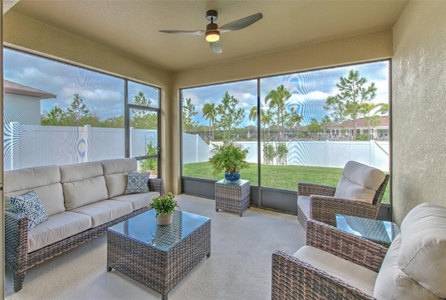 sunroom / solarium with plenty of natural light, ceiling fan, and a water view