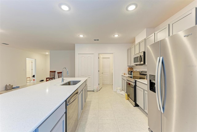 kitchen featuring gray cabinetry, light tile patterned floors, sink, and appliances with stainless steel finishes