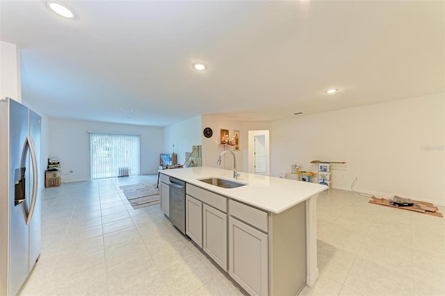 kitchen featuring gray cabinetry, stainless steel appliances, sink, a center island with sink, and light tile patterned flooring