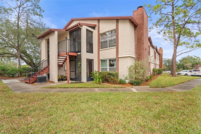 view of front of house featuring a front lawn and central AC unit