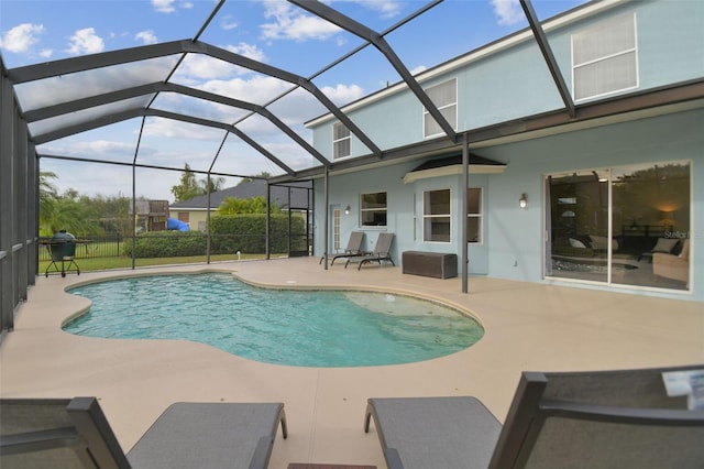 view of swimming pool with glass enclosure and a patio