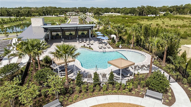 view of pool featuring a water view and a patio