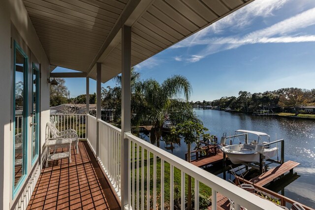 balcony featuring a water view and a dock