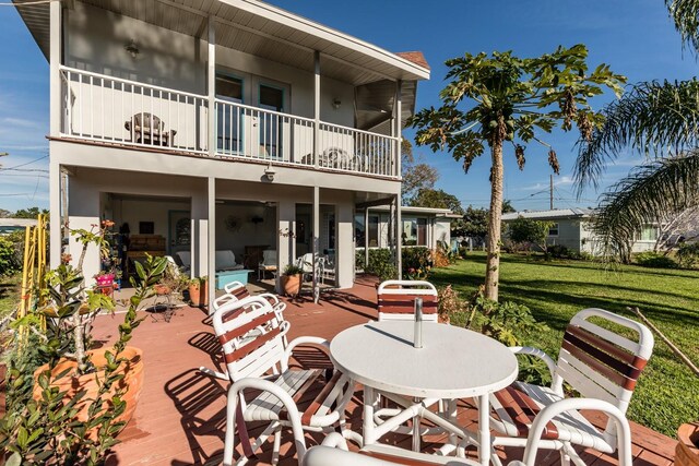 rear view of house with a yard and a balcony