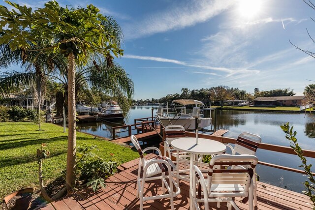 dock area with a yard and a water view