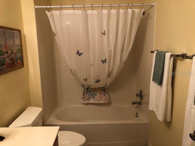 full bathroom featuring vanity, toilet, and shower / tub combo with curtain