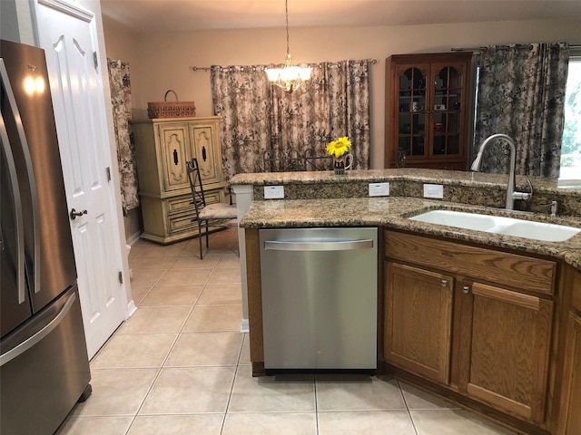 kitchen featuring sink, a notable chandelier, pendant lighting, light tile patterned flooring, and appliances with stainless steel finishes