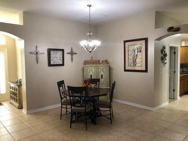 dining space featuring light tile patterned floors and a chandelier