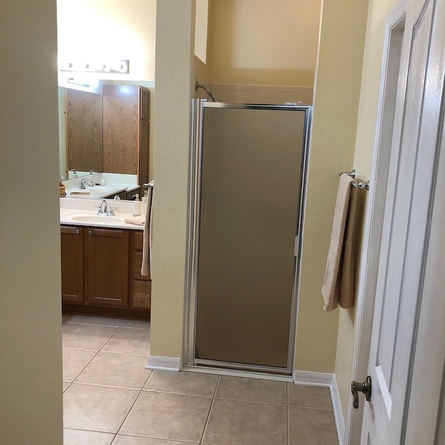 bathroom with tile patterned flooring, vanity, and walk in shower