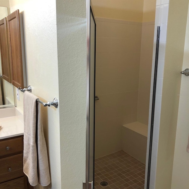 bathroom with vanity and tiled shower