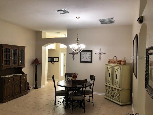 tiled dining space with a notable chandelier