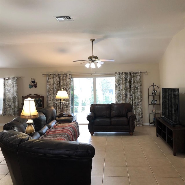 living room featuring ceiling fan, light tile patterned floors, and lofted ceiling