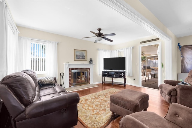 living room with a fireplace, hardwood / wood-style floors, a wealth of natural light, and ceiling fan