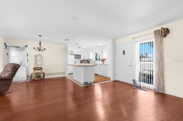 interior space with sink, wood-type flooring, and a notable chandelier