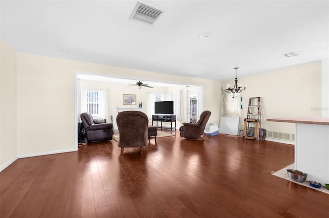 sitting room featuring ceiling fan with notable chandelier and dark hardwood / wood-style flooring