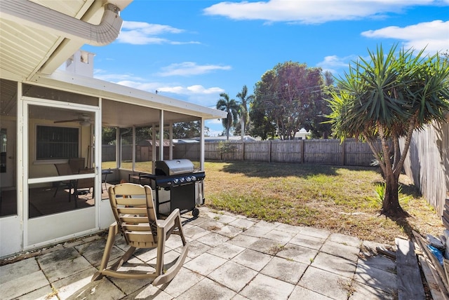 view of patio with area for grilling and a sunroom