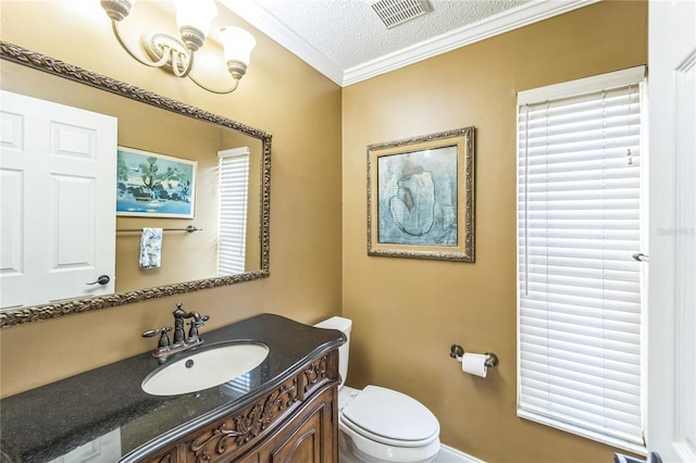 bathroom with visible vents, toilet, vanity, a textured ceiling, and crown molding