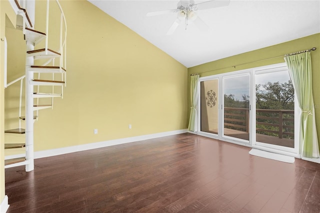 unfurnished room featuring a ceiling fan, vaulted ceiling, wood finished floors, baseboards, and stairs