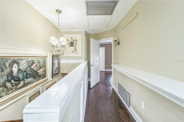 corridor with baseboards, dark wood-style flooring, visible vents, and an inviting chandelier