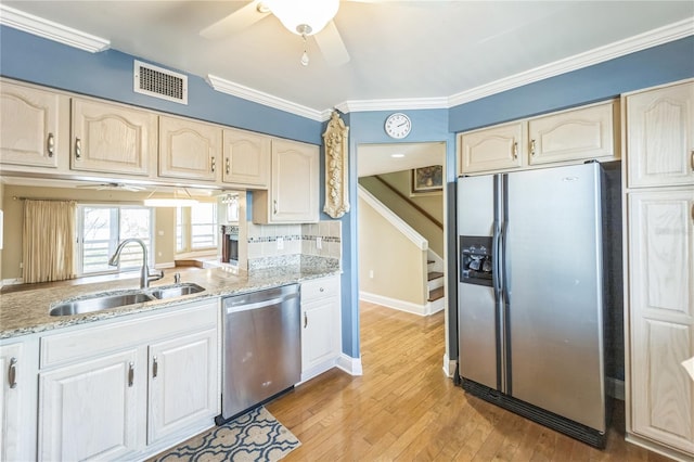 kitchen with stainless steel appliances, a sink, visible vents, light wood-type flooring, and crown molding