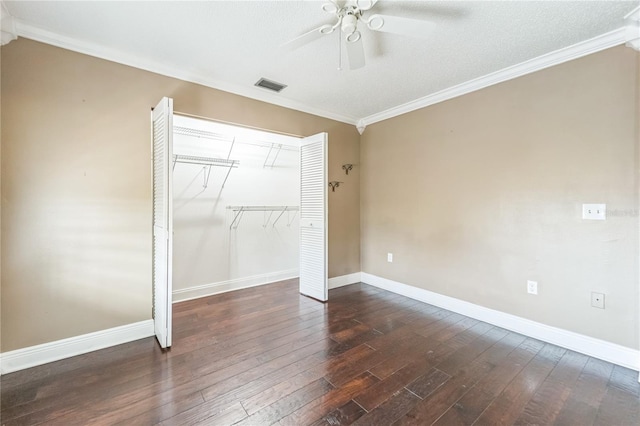 unfurnished bedroom with dark wood-type flooring, visible vents, and crown molding