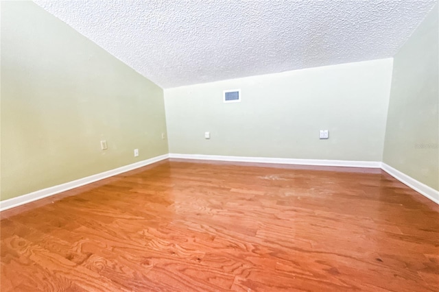 spare room featuring a textured ceiling, visible vents, and baseboards