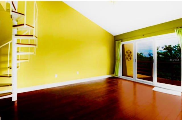 1710 Lighthouse Ter S Unit 1, South Pasadena, FL 33707 - spare room with stairway, lofted ceiling, wood finished floors, and baseboards