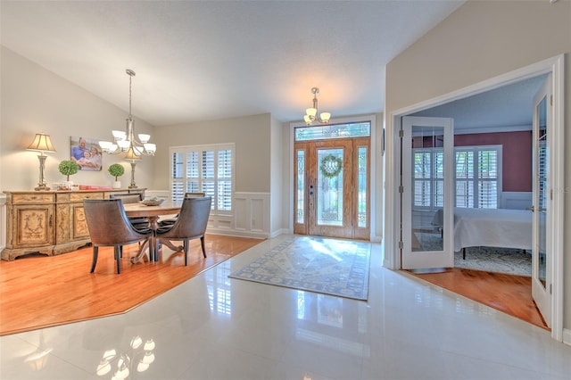 tiled entrance foyer with vaulted ceiling and an inviting chandelier