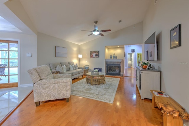 living room featuring ceiling fan, light hardwood / wood-style floors, and lofted ceiling