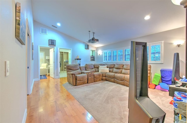 cinema room featuring light hardwood / wood-style floors and lofted ceiling