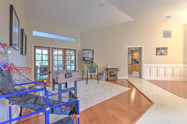 living room featuring french doors, hardwood / wood-style flooring, and high vaulted ceiling