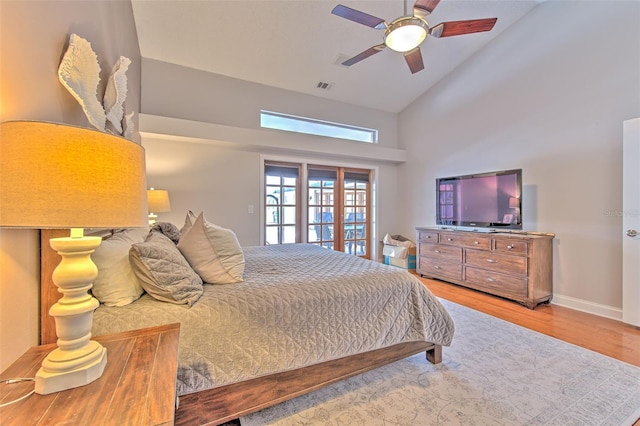 bedroom featuring ceiling fan, light hardwood / wood-style flooring, and high vaulted ceiling