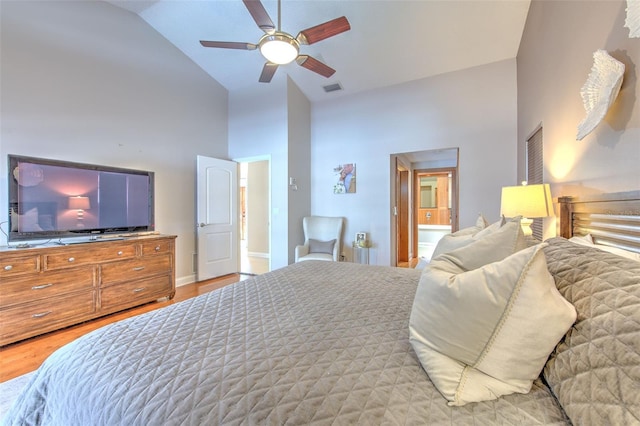 bedroom with ensuite bath, ceiling fan, high vaulted ceiling, and light hardwood / wood-style floors