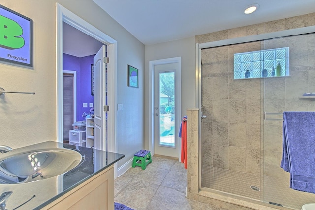 bathroom with tile patterned flooring, sink, and walk in shower