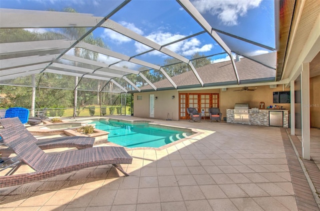 view of swimming pool with french doors, an outdoor kitchen, a jacuzzi, a lanai, and a patio area