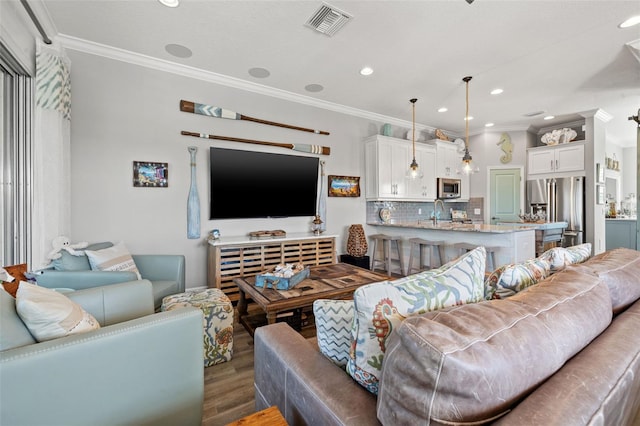 living room with dark hardwood / wood-style floors, sink, and crown molding