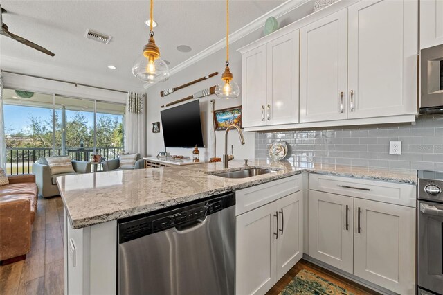 kitchen featuring pendant lighting, white cabinets, sink, kitchen peninsula, and stainless steel appliances