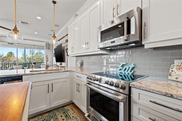 kitchen with sink, stainless steel appliances, decorative light fixtures, decorative backsplash, and white cabinets