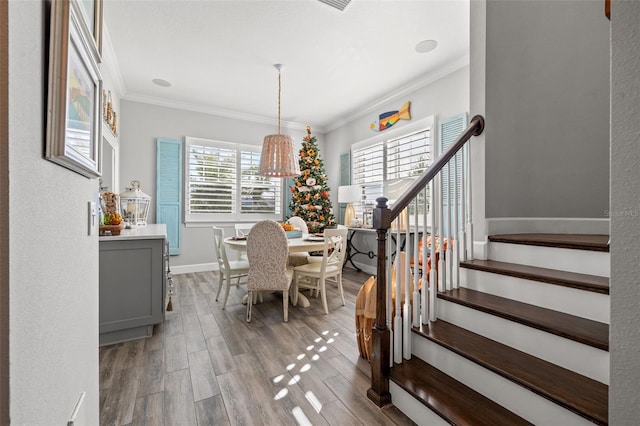 dining area with crown molding and light hardwood / wood-style flooring