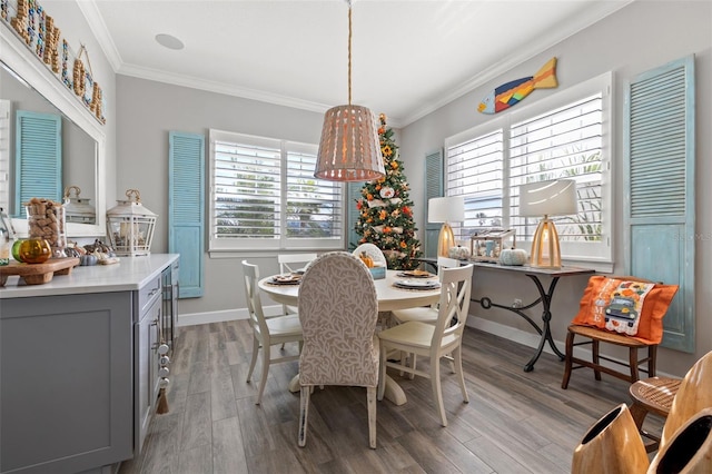 dining space with light hardwood / wood-style floors and ornamental molding