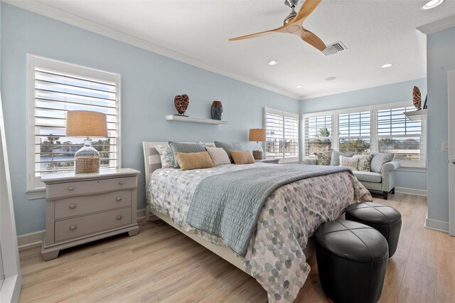 bedroom featuring ceiling fan, light hardwood / wood-style floors, and ornamental molding