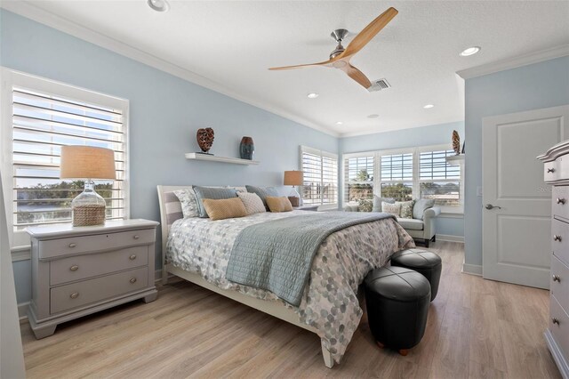 bedroom with light hardwood / wood-style flooring, ceiling fan, and ornamental molding