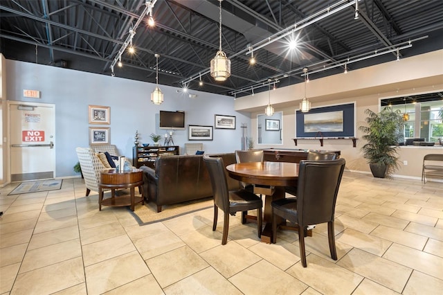 dining space with a towering ceiling and light tile patterned flooring